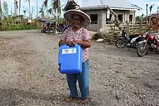 Distributing jerrycans to help people store clean drinking water in the Philippines