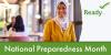 A woman with her hair wrapped looks off into the distance smiling. National Preparedness Month.